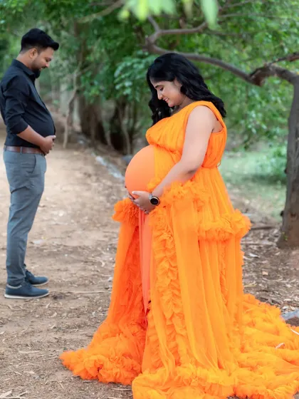 A fun and lighthearted moment between parents-to-be. The dad playfully holds his belly, sharing a laugh with his partner.