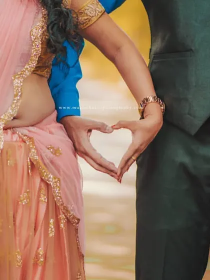 Creating a heart with their hands, a simple and sweet symbol of their love story, captured during their outdoor pre-wedding session.