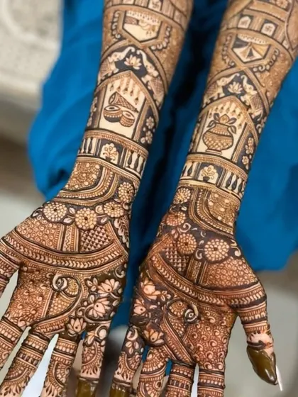 Another view of the kalash and diya design, showing the symmetry and precision of the work on both hands.