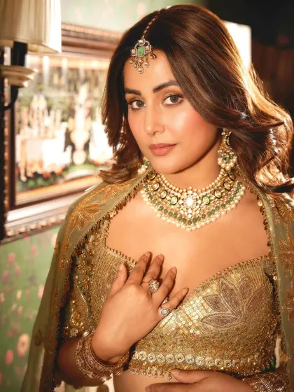 Hina Khan looking regal and poised, her hand gently touching the opulent necklace that was custom-designed for her.