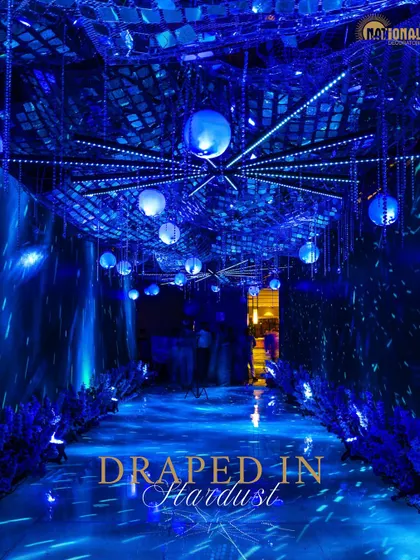 The entrance to this Sangeet was a tunnel draped in stardust. I used mirrored ceilings, hanging orbs, and dynamic blue lighting to create a futuristic and glamorous passageway that set the tone for a high-energy celebration.