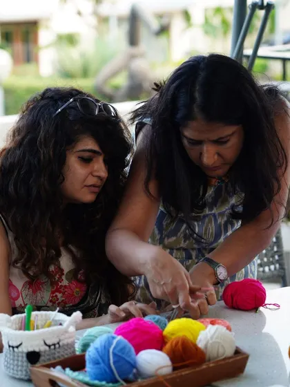 I always make sure to give one-on-one help during my workshops. Here I am guiding a student through a tricky part, surrounded by colorful yarn.