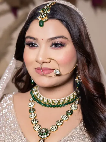 A beautiful bride with soft, neutral-toned makeup and stunning green jewelry. This look is a great example of how to balance makeup with statement accessories.