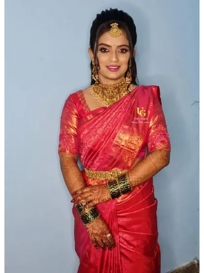 Geetha looking elegant and happy, fully ready for her wedding reception in her beautiful red saree.