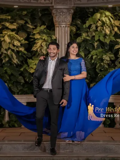This walking shot shows how a trail gown and suit look in motion. The royal blue fabric flows behind the couple, creating a sense of movement and romance.