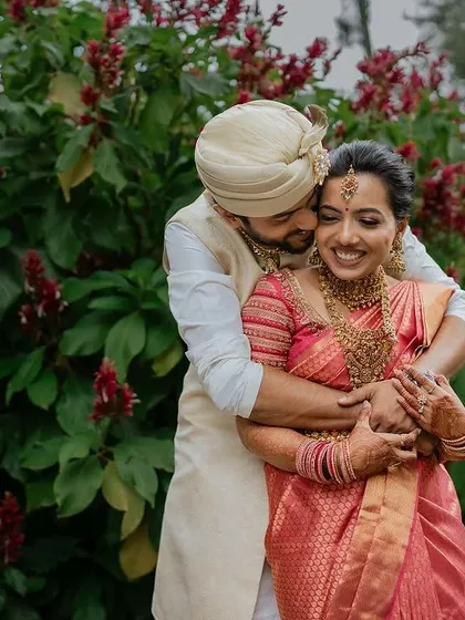 A warm, candid embrace against a backdrop of vibrant flowers. We love capturing the natural joy and affection between couples in beautiful outdoor settings.