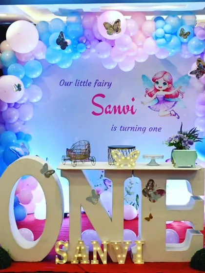 Our little fairy Sanvi is turning one! This enchanting fairy theme features a pastel balloon arch, a large "ONE" table, and cute fairy cutouts, creating a magical wonderland for her first birthday.