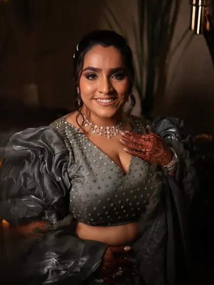 A smiling portrait of the same sangeet look. The makeup is designed to be both glamorous and joyful, enhancing her beautiful smile.
