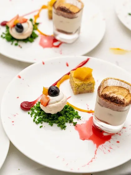 An exquisite dessert plating for a 50th birthday celebration. This trio of treats, including a mini tiramisu and fruit meringue, shows how we add a touch of artistry to every course.