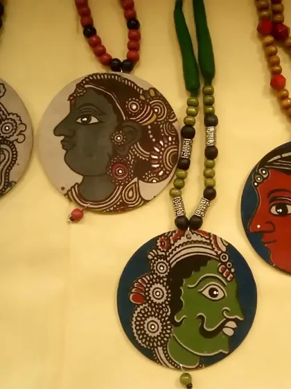 A display of my Kalamkari face pendants, each with a unique expression and color palette. These pieces showcase the diversity and artistic richness of this traditional pen-art.