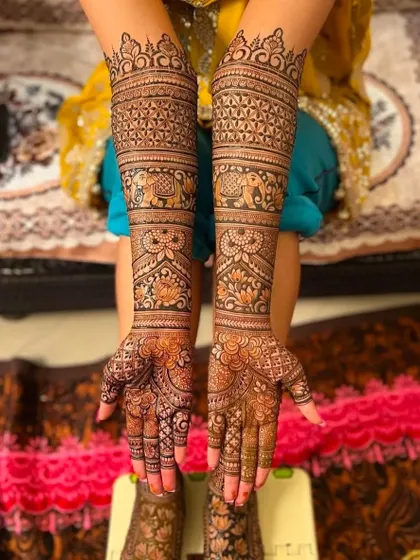 A full bridal design with bands of elephants and floral patterns extending all the way up the arms.