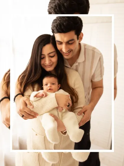 A classic family portrait with new parents holding their baby. We use soft, natural light in our studio to create a warm and inviting atmosphere.