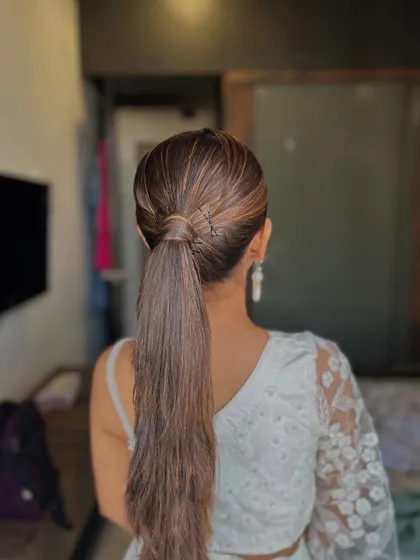 A sleek and modern high ponytail is a fantastic choice for a contemporary look. This style is clean, polished, and keeps the focus on the client's face and outfit, making it perfect for a stylish party or formal event.