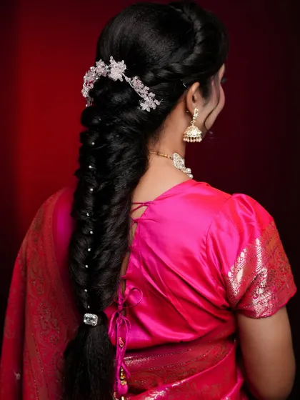 A classic fishtail braid, elegantly styled for a traditional look. This hairstyle is decorated with a crystal hairpiece and small pearls, showcasing the art of accessorizing.