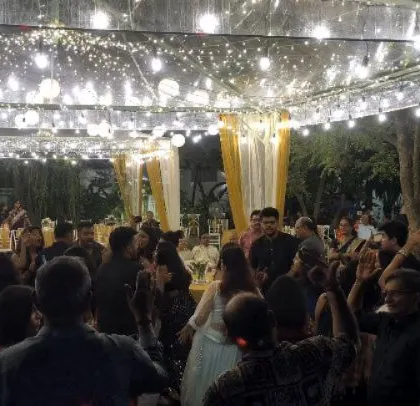 The dance floor is packed under a canopy of fairy lights.