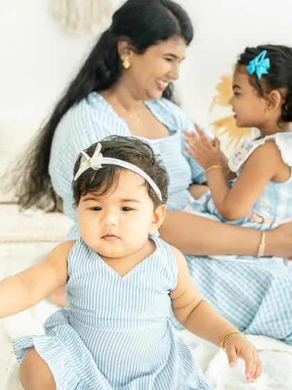 A candid moment between a mother and her older daughter, while the baby curiously observes. It’s these unposed, layered moments that truly tell a family's story.