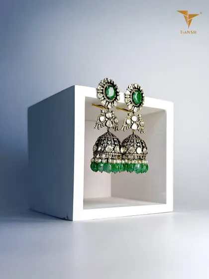 These traditional kundan jhumkas are handcrafted with uncut diamonds and emeralds, where timeless design meets precision craftsmanship.