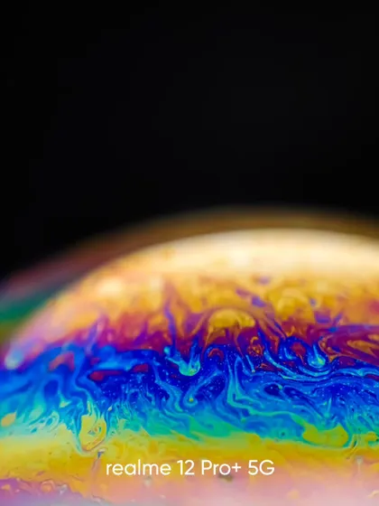 A close up of the intricate, flowing patterns on a soap bubble, shot with a macro lens. The vibrant colors against the black background create a striking visual.