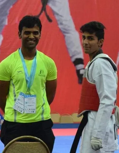 Standing with an Asian Taekwondo champion from my academy. My goal is to guide students from their first kick to the top of the podium.