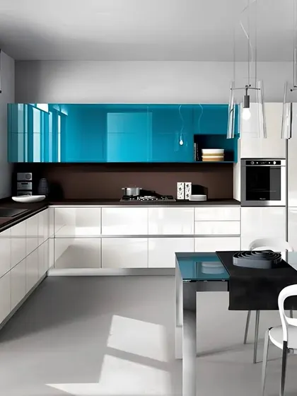 A sleek and modern kitchen featuring high-gloss blue and white cabinets. The integrated dining table and minimalist pendant lights make this a perfect example of a contemporary kitchen-diner.
