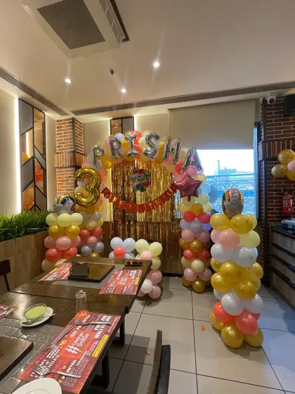 A colorful rainbow-themed decoration for a 3rd birthday party in a restaurant. We can transform any space into a festive party zone.
