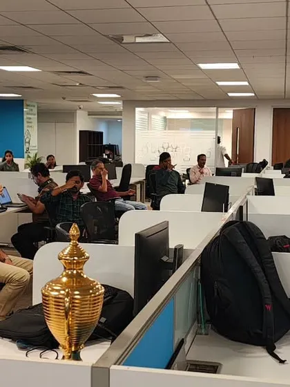A wide view of a pranayama (breathing) session in an open-plan office, showing how easily these wellness practices can be integrated into the corporate environment.