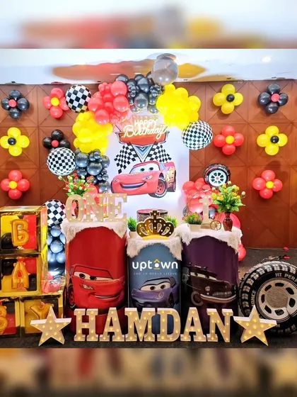 A high-energy Cars themed birthday party, complete with a checkered flag backdrop and Lightning McQueen props.