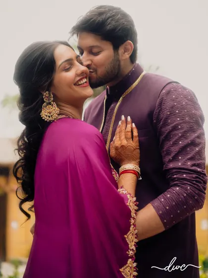 A sweet kiss on the cheek, this candid shot captures the affection and happiness of the couple during their Mehendi or Sangeet.