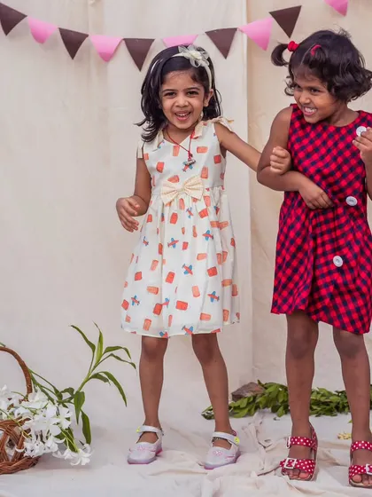 Two times the fun! This video shows sisters playing together in their coordinated outfits, one in a quirky print and the other in a classic check, proving that matching can also mean complementary styles.