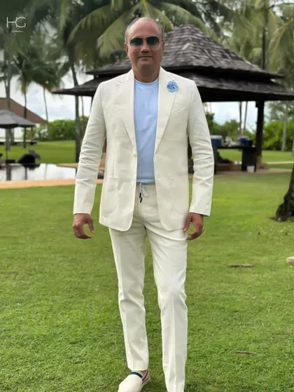 A client looking effortlessly stylish in a custom off-white linen suit. This look is perfect for a daytime event or a destination wedding, offering relaxed elegance.