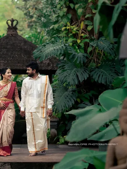 A post-wedding stroll through a serene, temple-like garden. This shot captures the couple hand-in-hand, embarking on their new journey together.