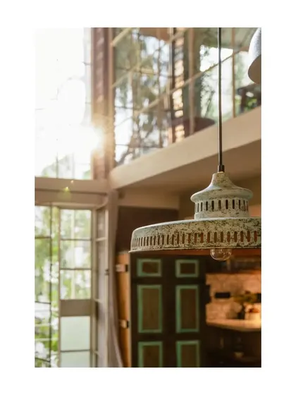 A vintage-style pendant light hangs in the double-height space, with a view through to a repurposed door on the upper level.