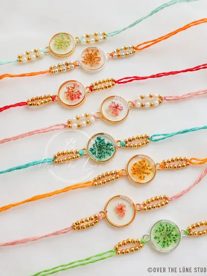 A lineup of my circular-shaped floral Rakhis. The colorful threads and delicate flowers inside make each piece a tiny work of art.