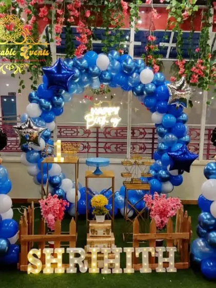 A classic Mickey Mouse theme with blue, white, and black balloons, Mickey-shaped balloon stands, and a circular backdrop.