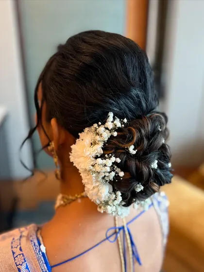 A side view of the messy bun, showing how the flowers are delicately placed throughout the hair to create a whimsical and ethereal effect.