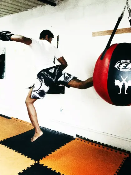 Putting everything into a flying kick on the wrecking ball. This type of training helps develop power, agility, and coordination, all crucial elements for a well-rounded striker.