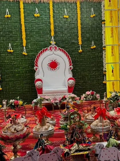A wide shot of a platter display for a naming ceremony with a paan leaf backdrop.