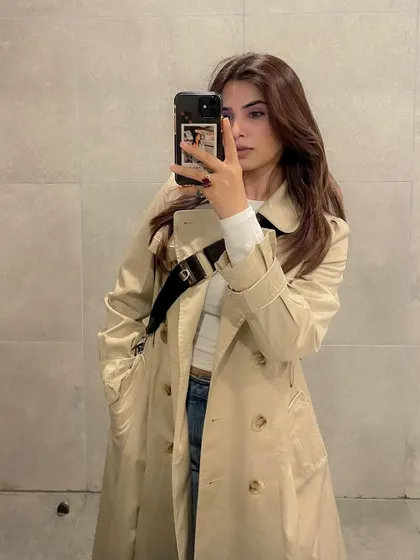 A mirror selfie in a timeless beige trench coat, a staple in my wardrobe.