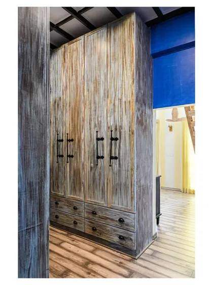 A view of the custom-made, distressed wood cupboards that form the walk-in wardrobe in the master bedroom.