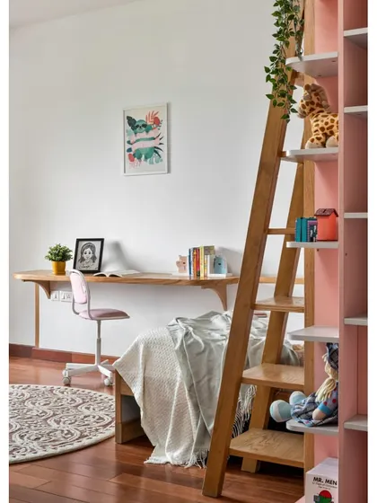 The daughter's room in 'Vasudhalayah' features a bunk bed with a sleek study unit below. The soft pink ambiance and white oak details create a delightful and creative space for play and study.