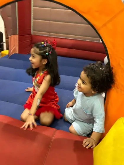 Even the youngest guests can have fun. Here, two toddlers are enjoying the bouncy castle, a safe and exciting activity for them.
