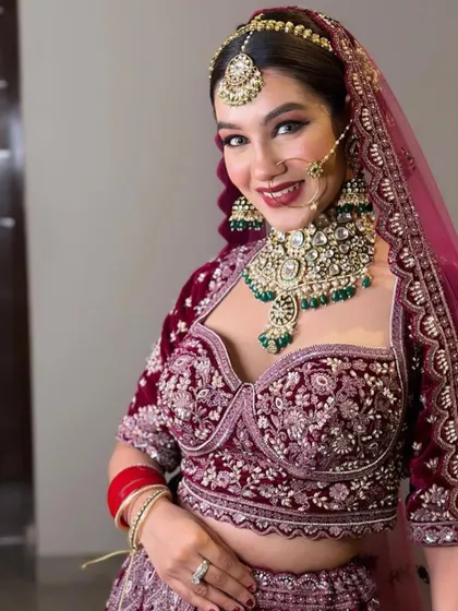 An amazing bridal look featuring a heavy kundan and emerald set with a corset-style blouse.