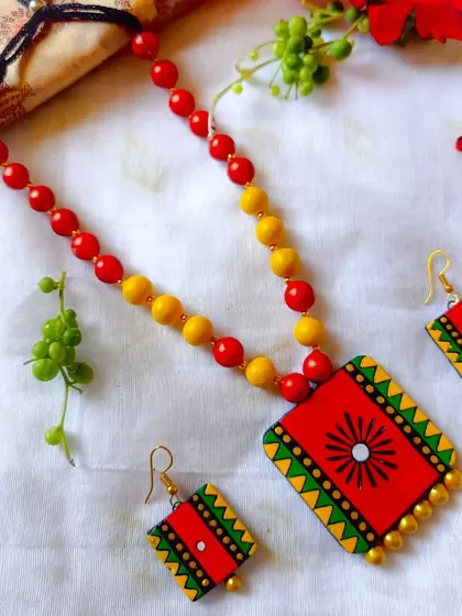 A simple rectangular pendant necklace with a beaded chain, available in a festive red and yellow. These are excellent, budget-friendly options for bulk gifting.