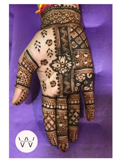 A close-up of the hand with the intricate patchwork design.