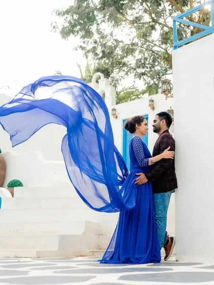 A vibrant pre-wedding shoot at a Santorini-themed location. This shows our versatility in creating different moods, from natural landscapes to stylized, architectural backdrops.