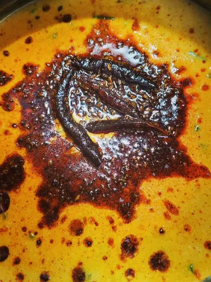 A view of the bubbling tadka as it hits the creamy kadhi, releasing all its wonderful aromas.