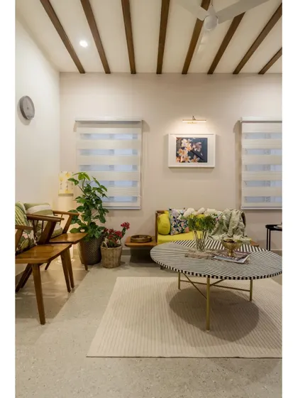 An informal living area in the Mathrukrupa residence, featuring wooden ceiling beams, eclectic furniture, and plenty of natural light.