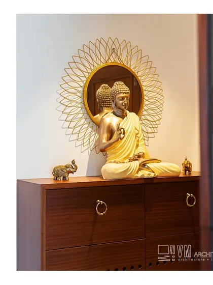 A serene corner in the Kozhikode apartment, where a Buddha statue is placed on a wooden chest against a decorative mirror, creating a peaceful and spiritual focal point.