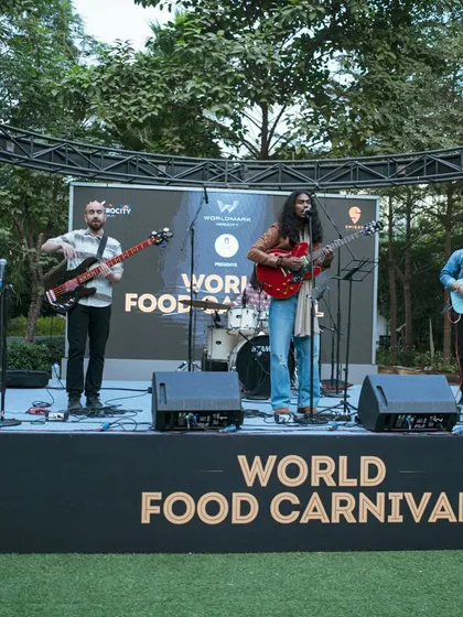 A full stage view of a band performing at the World Food Carnival. The live music is a key part of the experience, creating a perfect backdrop for a day of food and fun.