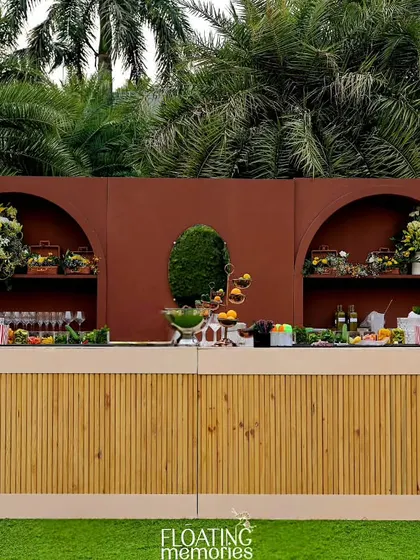 The custom bar was a statement piece, with a bamboo-textured front and a rich terracotta-colored backdrop. It was adorned with magnificent bouquets of yellow and white flowers, creating a stunning focal point.